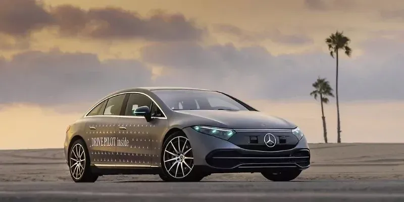 Mercedes-Benz EQS mit der Aufschrift „Drive Pilot inside“ vor Palmen im Abendlicht