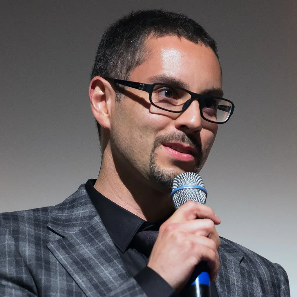 Patrick Schmid spricht mit Mikrofon auf einer Bühne