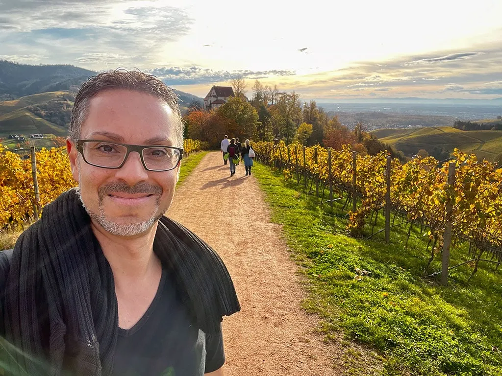 Patrick Schmid auf einem Weg durch herbstliche Weinberge
